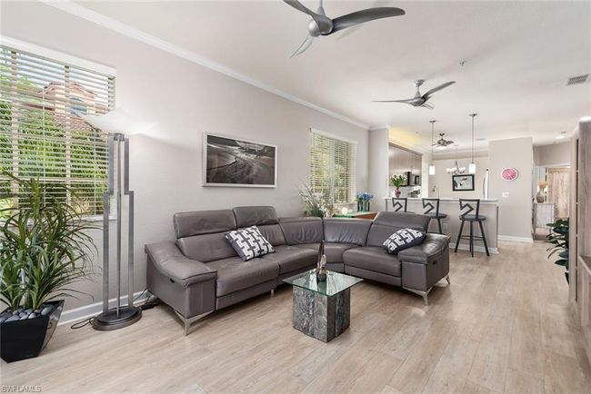 Living room with ceiling fan, ornamental molding, light hardwood / wood-style flooring, and plenty of natural light | Image 7