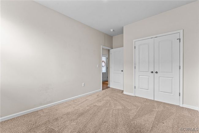 Unfurnished bedroom with carpet flooring, baseboards, and a closet | Image 40