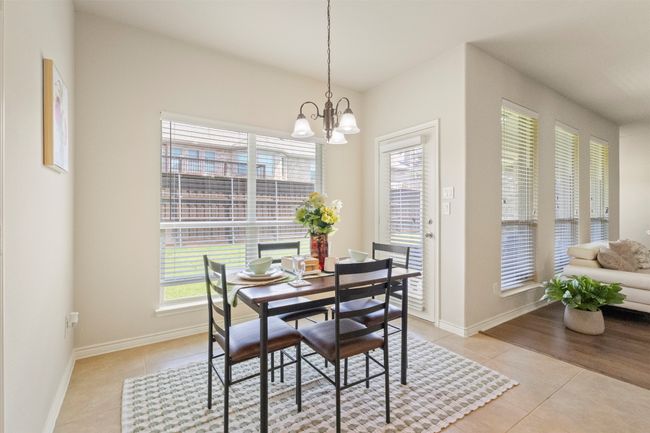 Dining space featuring light tile patterned floors, a chandelier, and baseboards | Image 11