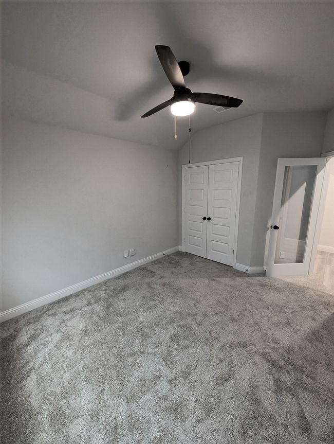 Unfurnished bedroom featuring a closet, baseboards, a ceiling fan, and carpet flooring | Image 6