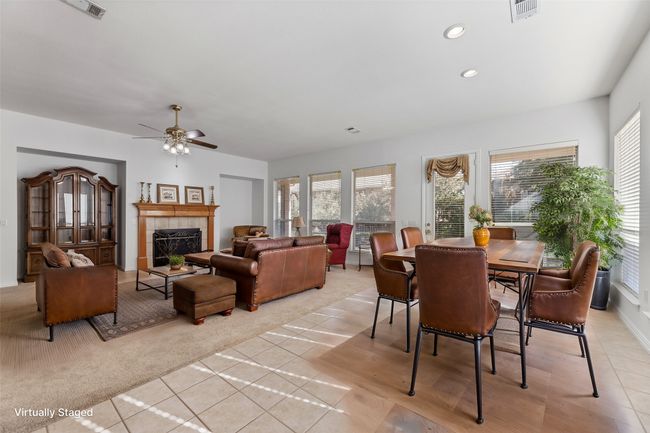 Carpeted dining area featuring a tiled fireplace, plenty of natural light, and ceiling fan | Image 21