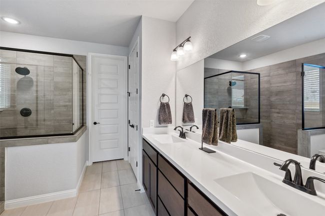 Full bathroom featuring double vanity, a tile shower, and tile patterned flooring | Image 18
