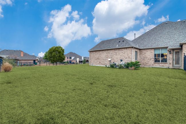 The breakfast room has an access door that goes out to the side yard. Behind the fence there is a green space that is maintained by the city. In the spring it is plush with Texas bluebonnets. | Image 30
