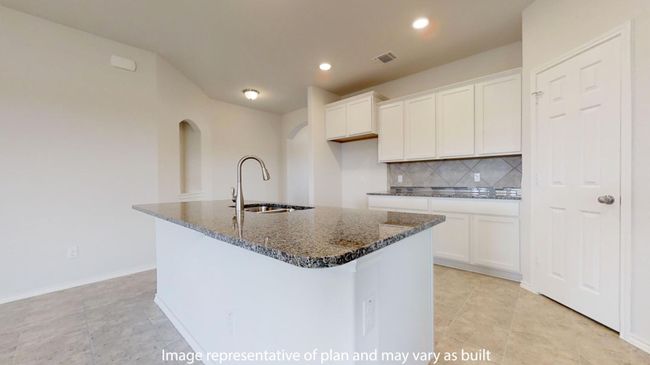 Kitchen featuring a sink, backsplash, dark stone countertops, white cabinets, and a center island with​​‌​​​​‌​​‌‌​‌‌​​​‌‌​​‌‌​‌​​​​​‌ sink | Image 9
