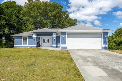 Single story home featuring a garage and a front lawn | Image 1