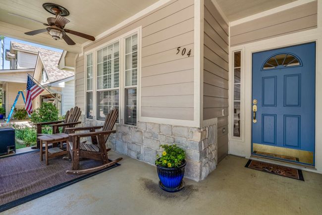 Entrance to property featuring covered porch, ceiling fan, and stone siding | Image 4