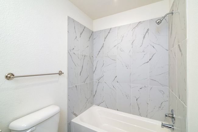 Bathroom with toilet and tiled shower / bath | Image 13