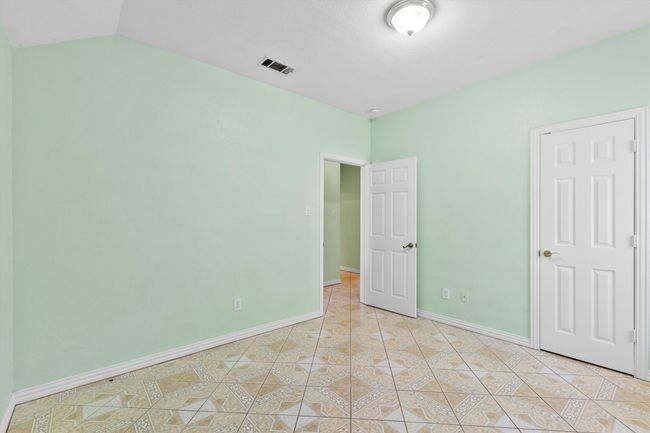 Unfurnished bedroom featuring baseboards and light tile patterned flooring | Image 6