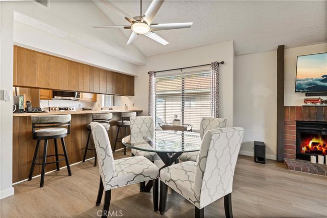 The bright dining area has a new ceiling fan and a cozy fireplace. | Image 8