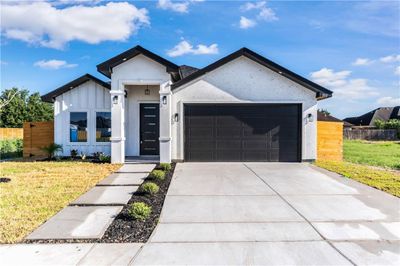 View of front facade with a garage and a front yard | Image 1