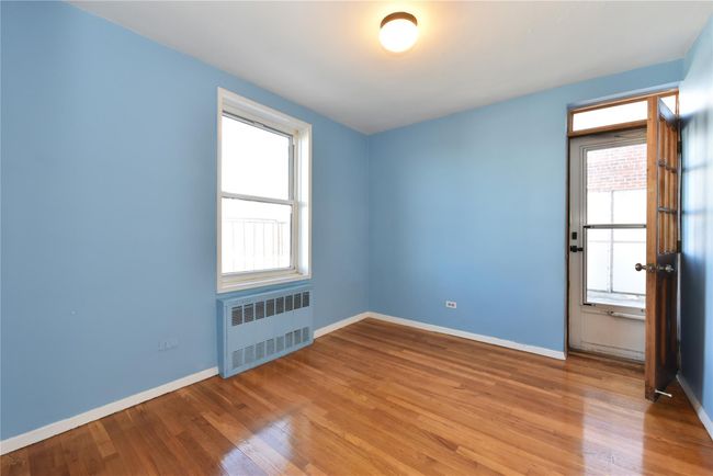 Spare room featuring hardwood / wood-style floors, a wealth of natural light, and radiator | Image 18