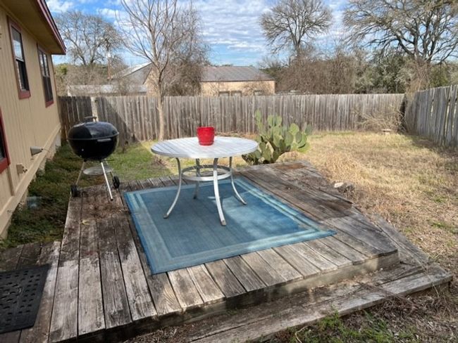 Wooden terrace with area for grilling and a fenced backyard | Image 6