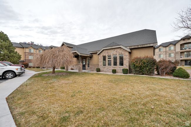 View of front of home with a front lawn, brick siding, roof with shingles, and stone siding | Image 18