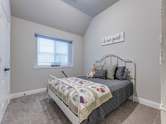 Carpeted bedroom with lofted ceiling | Image 23