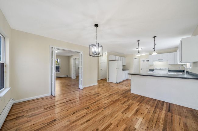 Kitchen featuring a sink, electric range oven, freestanding refrigerator, baseboard heating, and dark countertops | Image 9