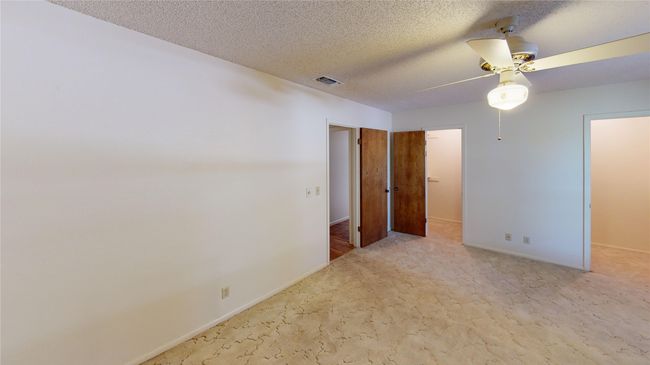 Carpeted spare room with ceiling fan, baseboards, and a textured ceiling | Image 14