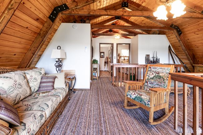 Living area with wood ceiling and carpet floors | Image 13