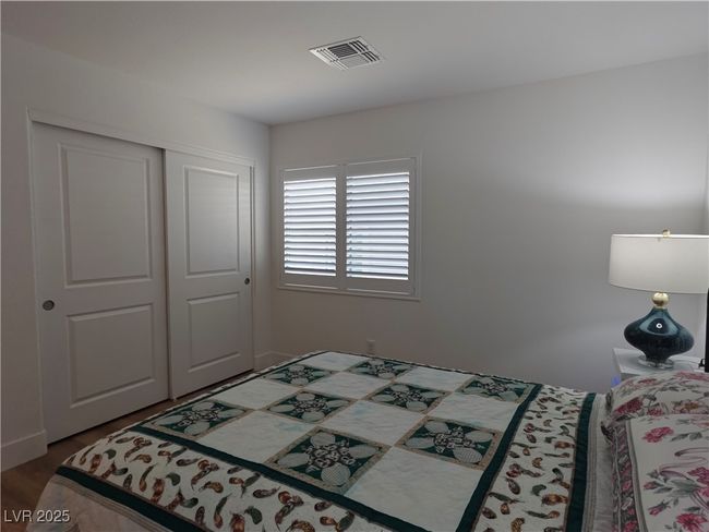 Bedroom with visible vents, wood finished floors, and a closet | Image 31