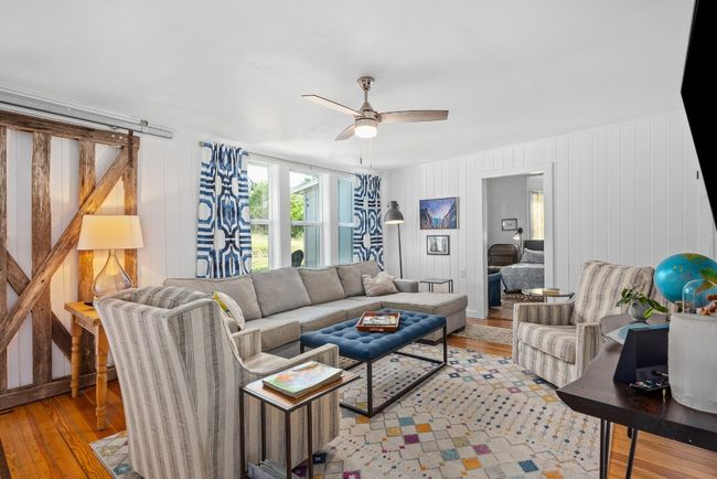Living area with light wood finished floors and a ceiling fan | Image 9