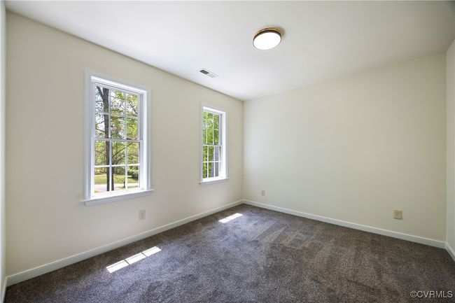 Spare room with baseboards, dark colored carpet, and visible vents | Image 27