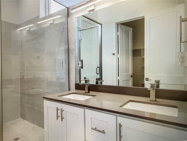 Bathroom featuring a sink, double vanity, and a stall shower | Image 6