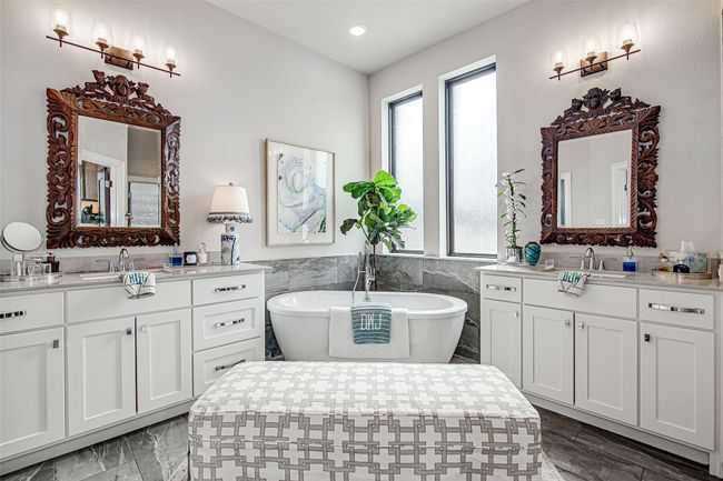 Full bath featuring two vanities, marble finish floor, a sink, and a soaking tub | Image 33