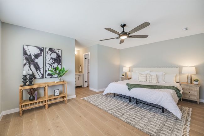 Bedroom with light wood-style tile floors, ceiling fan, and ensuite bath | Image 11