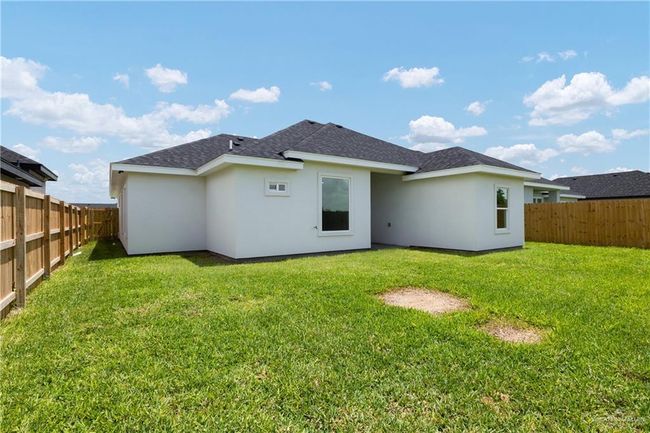Rear view of house with roof with shingles, stucco siding, and a fenced backyard | Image 15