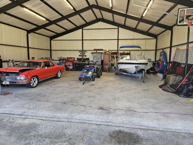 This Garage/Workshop was used as a hangar for a helicopter by the previous owners. It provides plenty of storage for a boat, cars with enough space left over for a workshop area. This building is wired for lighting and outlets and has an outside water faucet. | Image 37