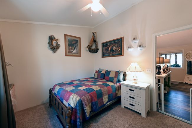 Bedroom with ornamental molding, dark carpet, and ceiling fan | Image 38