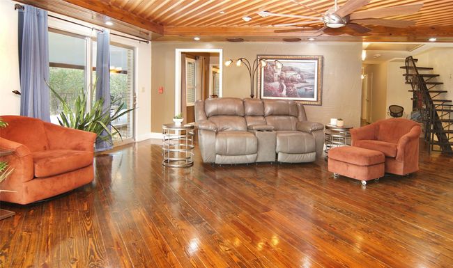 Warm wood floors and the beautiful copper clad ceiling give this living area such a great vibe. The free flowing stairway leads to an upstairs bonus room. | Image 8