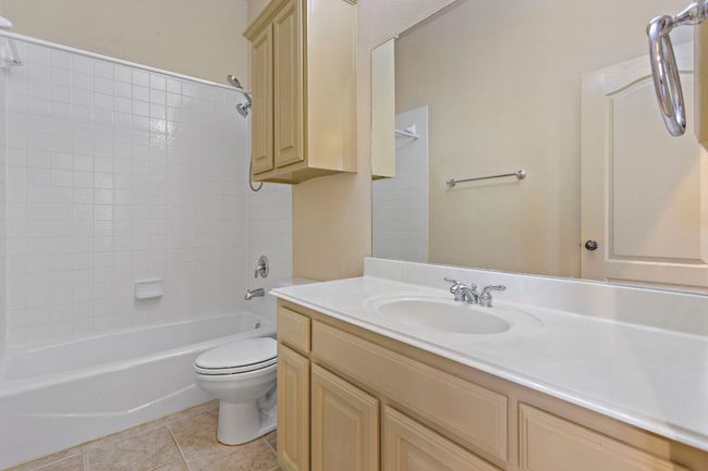 Full bath featuring toilet, vanity, tile patterned floors, and shower / bath combination | Image 25