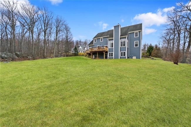 Back of property with a yard, a deck, and a chimney | Image 39
