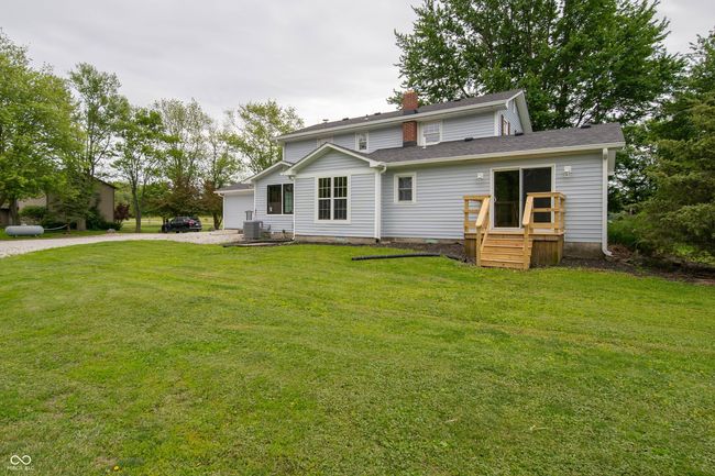 view of front of home featuring central AC unit, a front yard, a chimney, roof with shingles, and driveway | Image 42