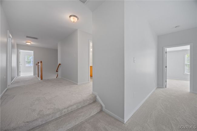 Corridor featuring baseboards, visible vents, an upstairs landing, and carpet | Image 25
