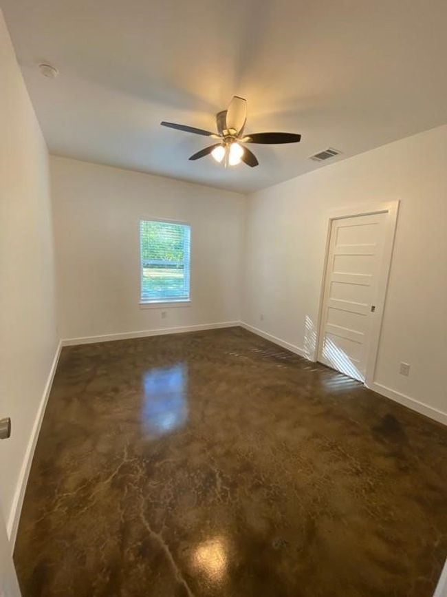 Unfurnished room featuring baseboards, a ceiling fan, finished concrete flooring, and a smoke detector | Image 13