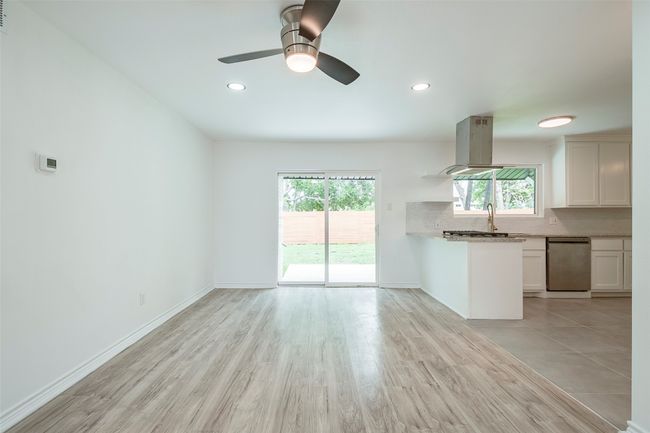 Kitchen with stainless steel dishwasher, healthy amount of natural light, tasteful backsplash, island range hood, and recessed lighting | Image 7