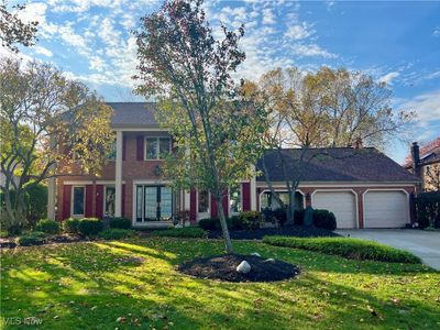 View of front facade with a front lawn and a garage | Image 1