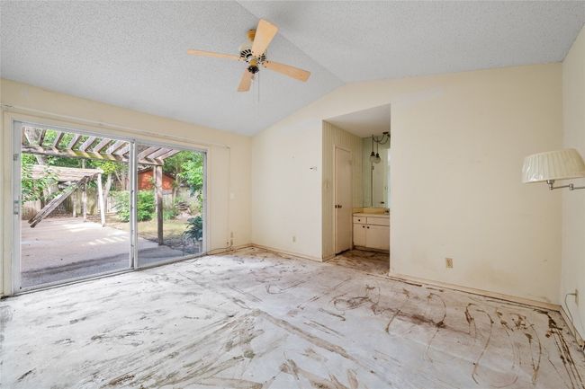 Unfurnished room featuring lofted ceiling, ceiling fan, and a textured ceiling | Image 7