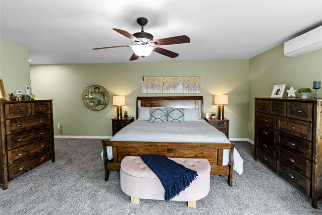 Carpeted bedroom featuring an AC wall unit and a ceiling fan | Image 49