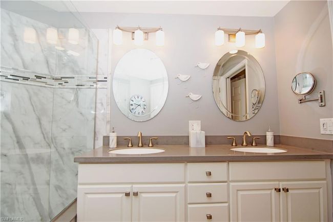 Dual vanity features quartz countertops and modern hardware, lighting and mirrors. | Image 22