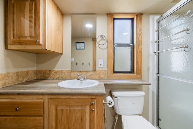 Full bath featuring toilet, vanity, and a shower with door | Image 10