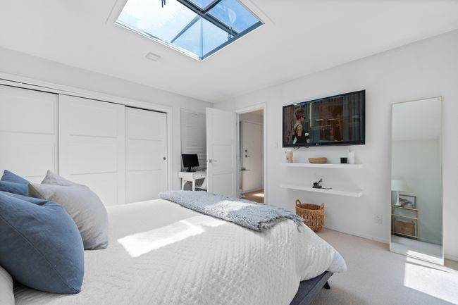 Bedroom featuring a skylight, a closet, carpet floors, and a desk | Image 17