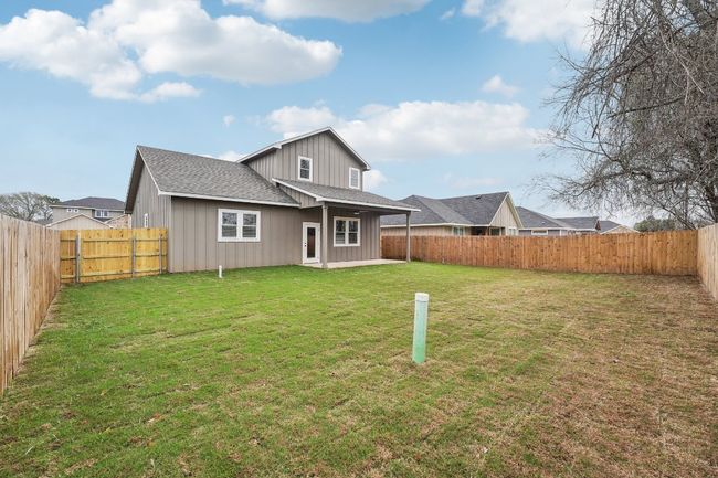 Back of property with a patio, a lawn, a fenced backyard, and roof with shingles | Image 37