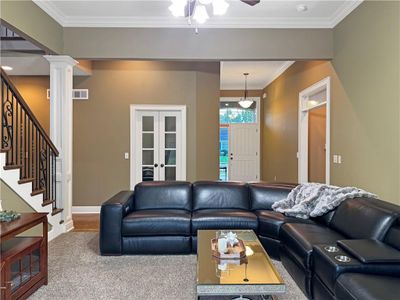 Living room with ornamental molding, decorative columns, carpet, and ceiling fan | Image 2