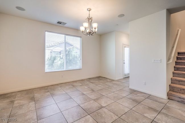 Spare room featuring visible vents, an inviting chandelier, light tile patterned flooring, baseboards, and stairs | Image 15
