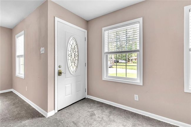 Carpeted entryway with baseboards and a healthy amount of sunlight | Image 8