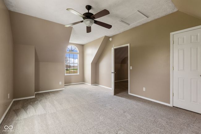 additional living space with visible vents, baseboards, attic access, carpet flooring, and lofted ceiling | Image 26
