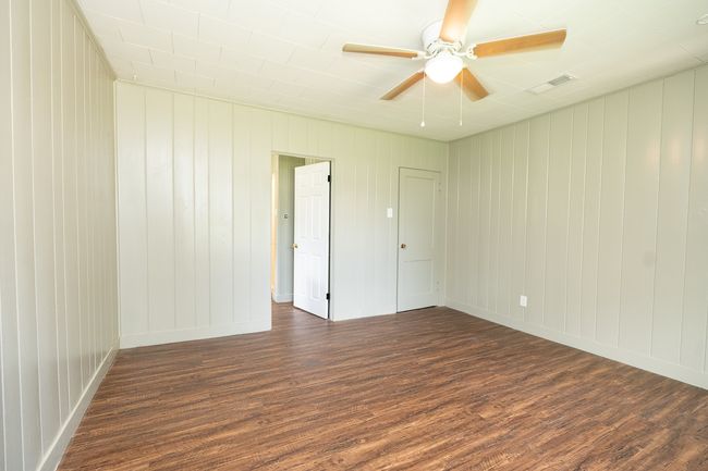 Empty room with a ceiling fan and wood finished floors | Image 20