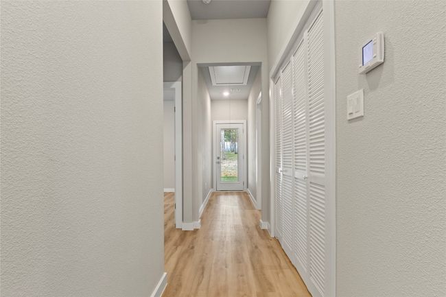 A spacious hallway leading to the bedrooms and a stunning covered patio—shown from a different angle to enhance its inviting flow and backyard views. | Image 15